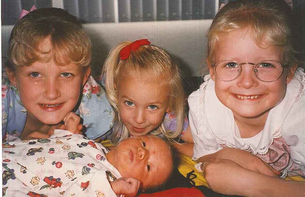 Garrett as a baby and his three older sisters.