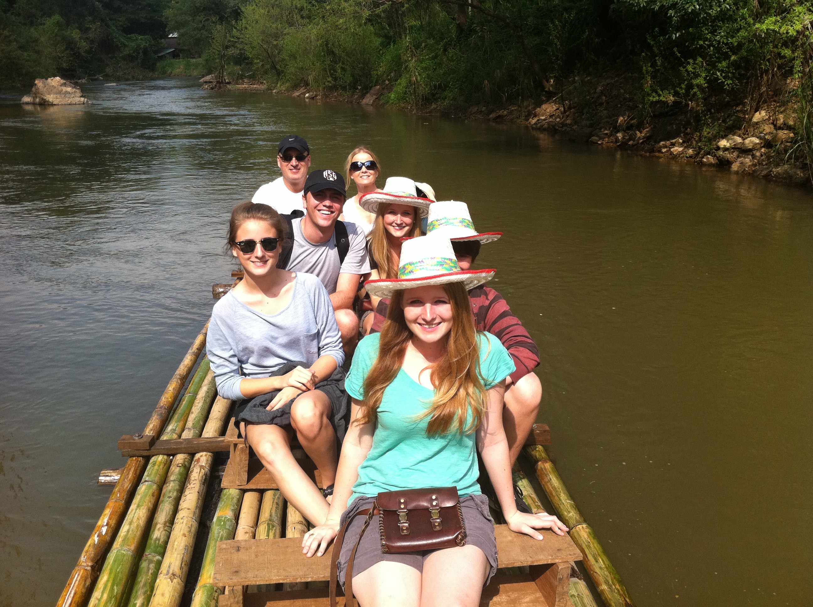 Family photo riding a bamboo boat in Thailand